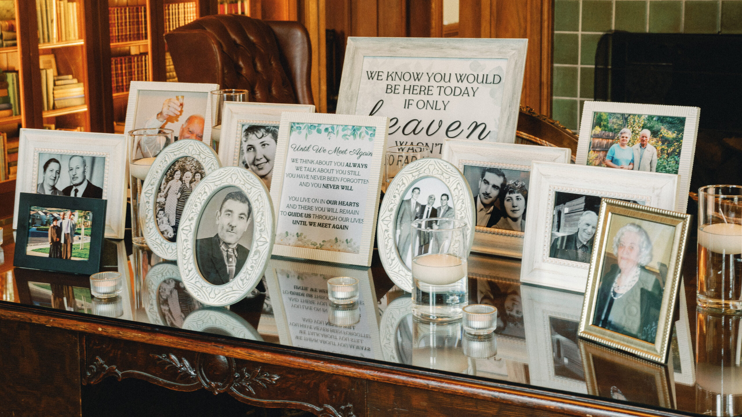 Wedding day photography of a touching family heritage memory table with framed vintage photos.