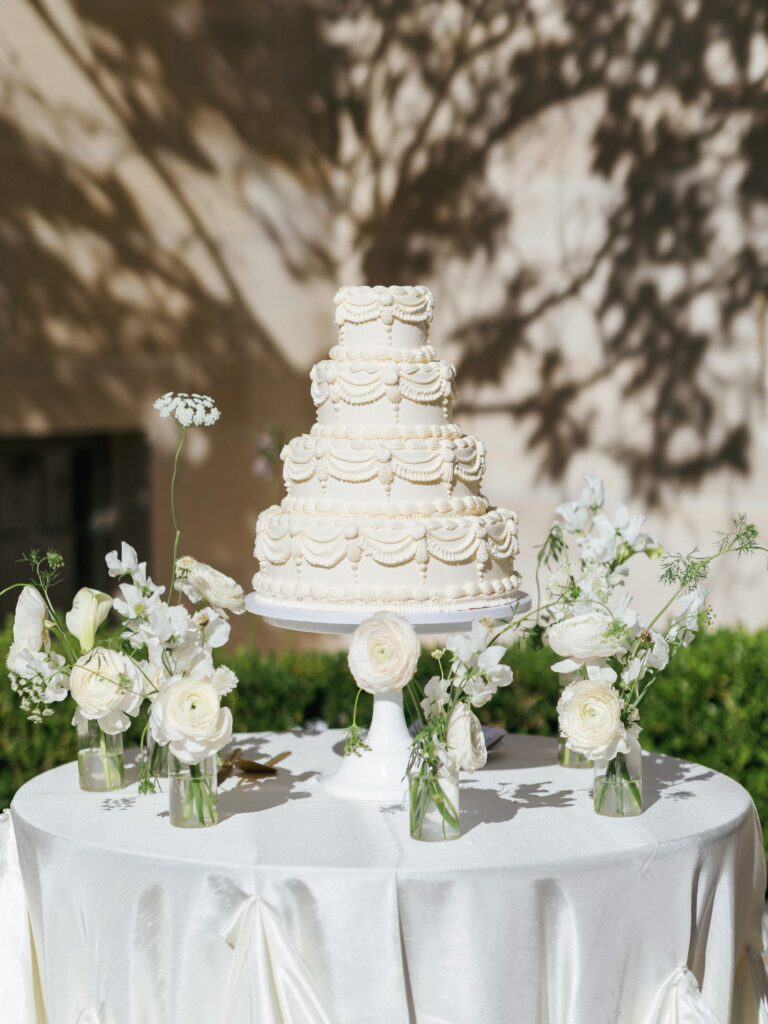 Vintage style wedding cake photoshoot featuring a multi-tiered white Lambeth cake decorated with flowers.