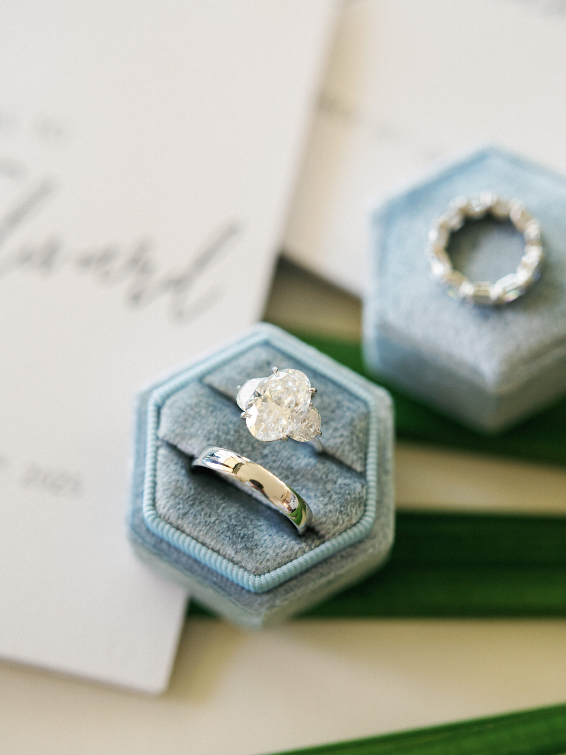 Wedding ring box detail with blue invitation paper