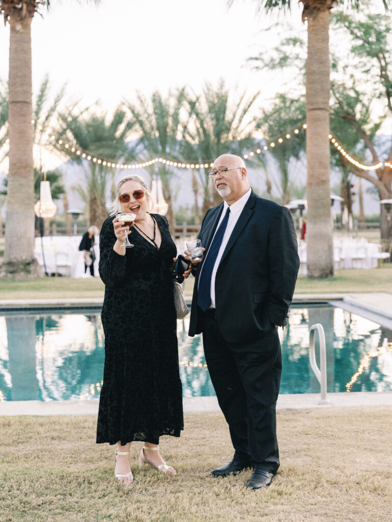 Elegant poolside wedding party at a luxury villa featuring palm trees and ambient lighting
