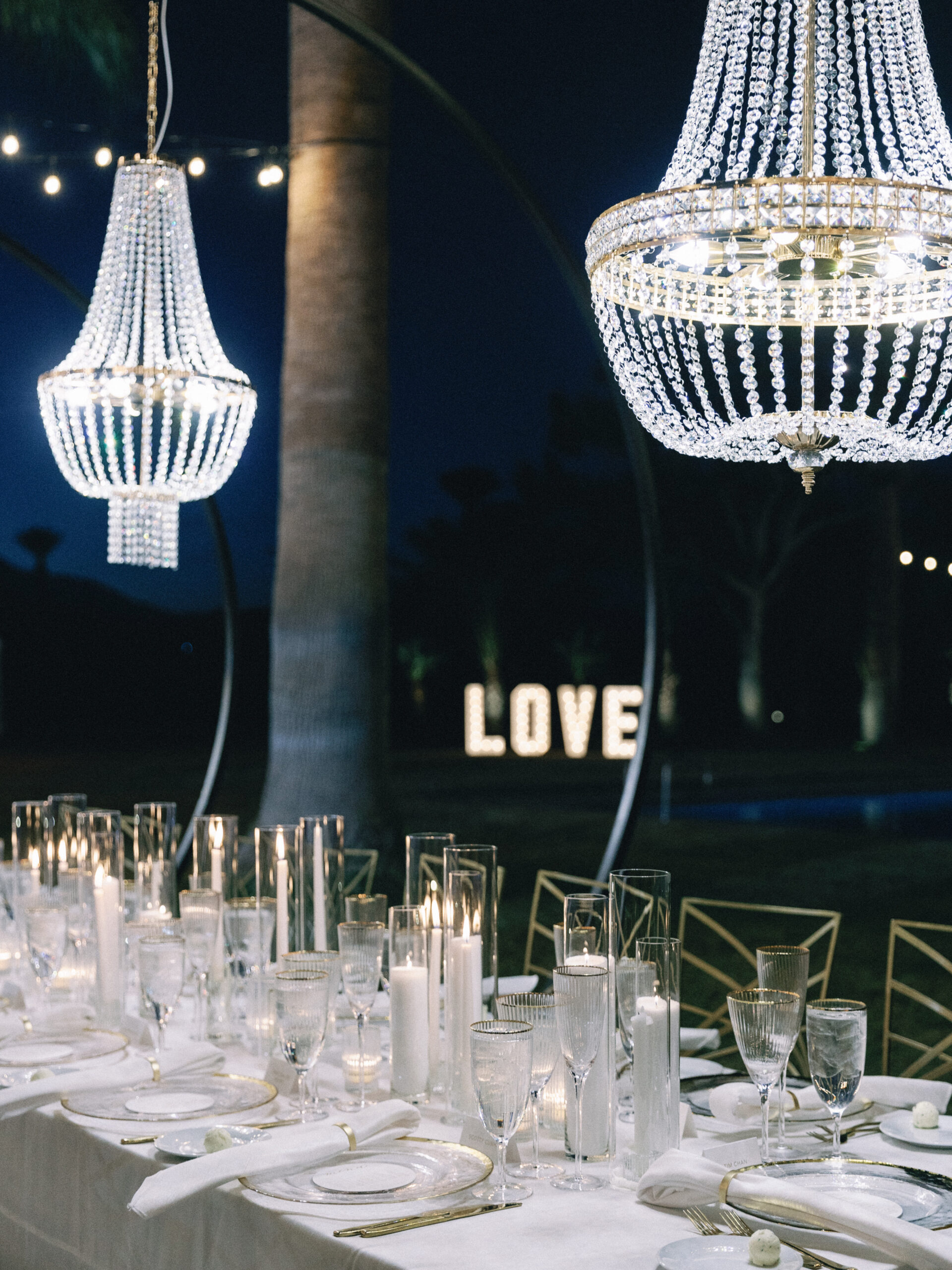 Reception dinner table with chandeliers and candlelight