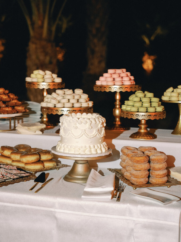 Dessert table setup with a wedding cake and assorted pastries for a destination wedding