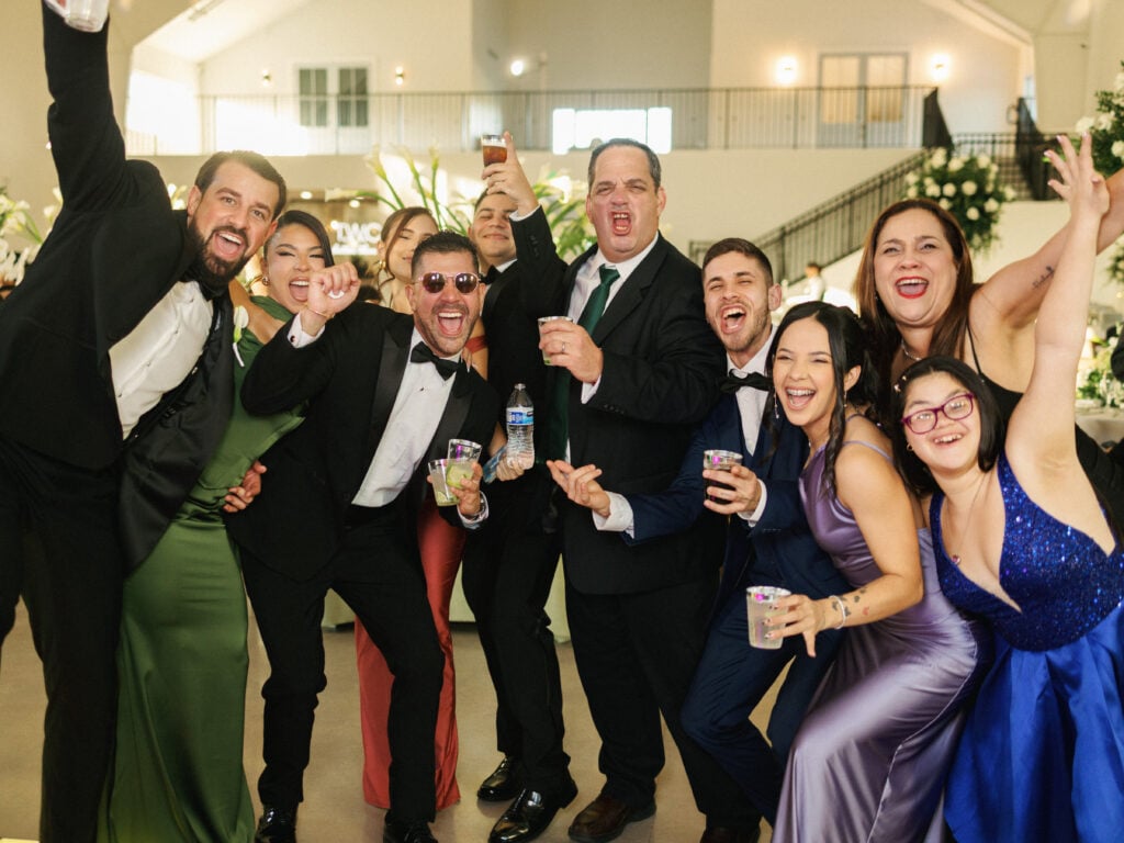 Wedding guests dancing and celebrating with drinks at a reception party