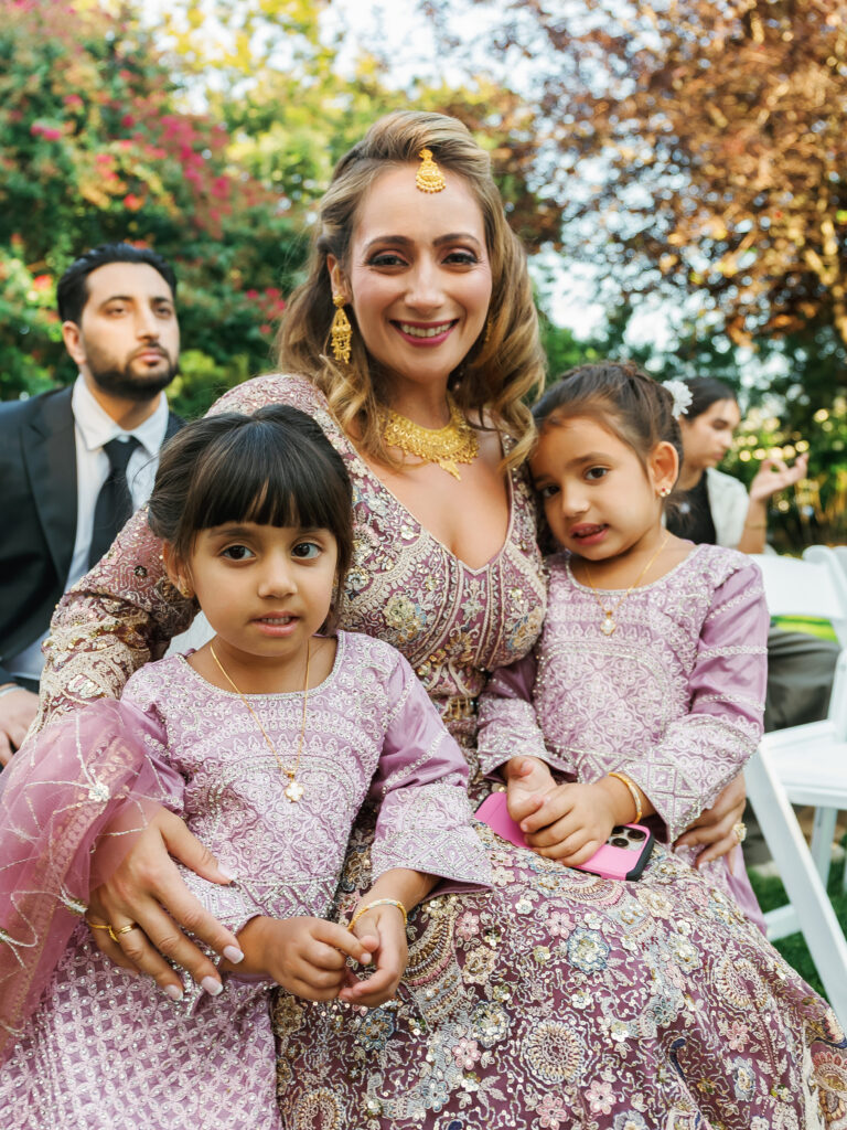 South Asian wedding guest fashion featuring an intricate embellished pastel outfit with traditional gold jewelry and maang tikka