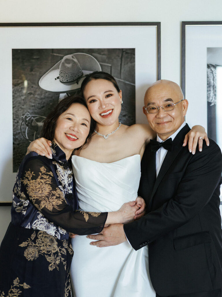 Elegant wedding photoshoot of a happy bride posing with her parents on her wedding day.