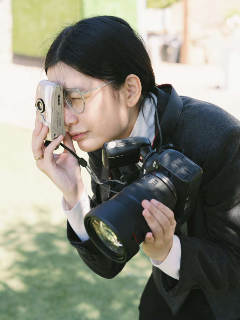 Editorial wedding photographer behind the scenes capturing candid moments with mixed media and natural lighting.