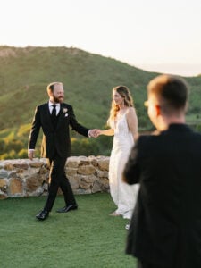 Professional videographer filming the bride and groom at sunset as part of the ultimate wedding videography checklist guide