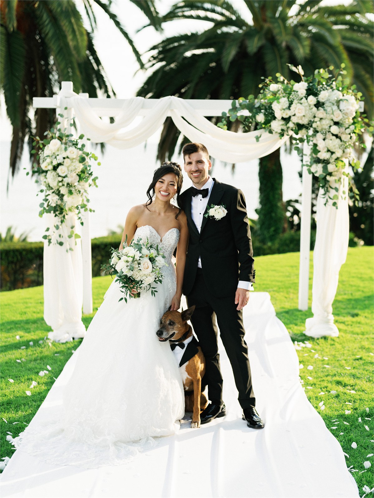 Wedding couple standing beneath a ceremony arch