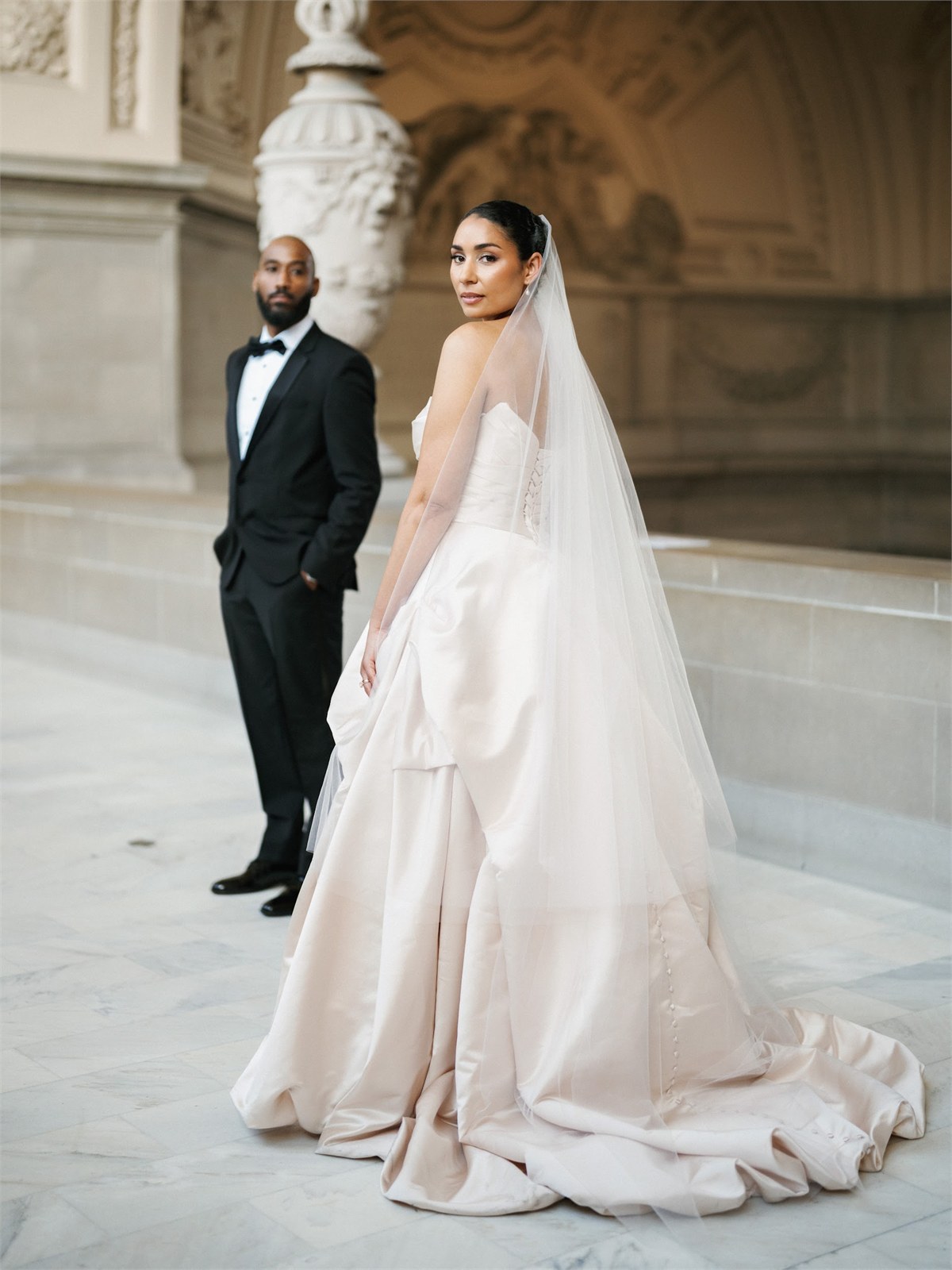 Wedding couple standing in front of a formal stone building