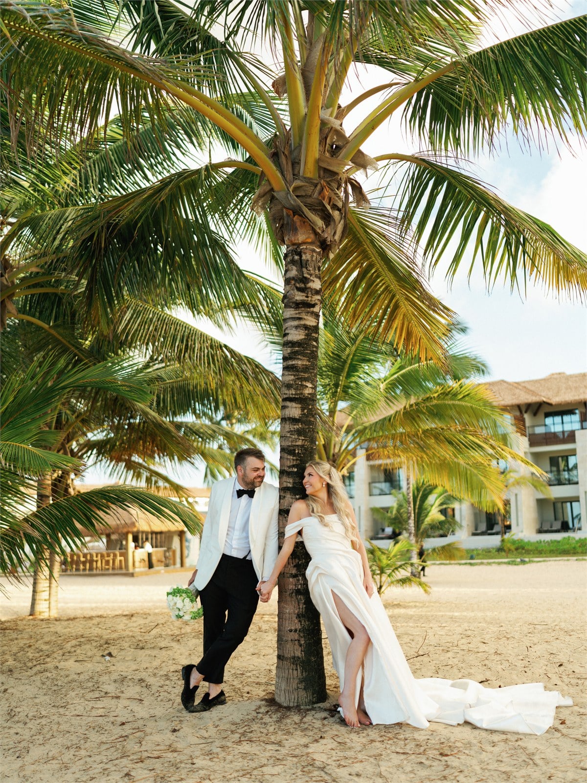 Wedding couple standing near palm trees