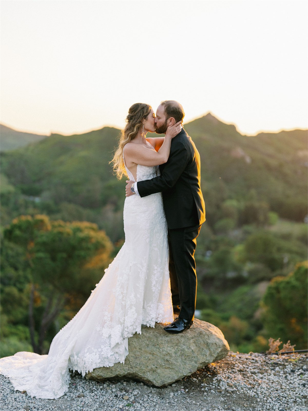 Wedding couple standing together with hills behind them