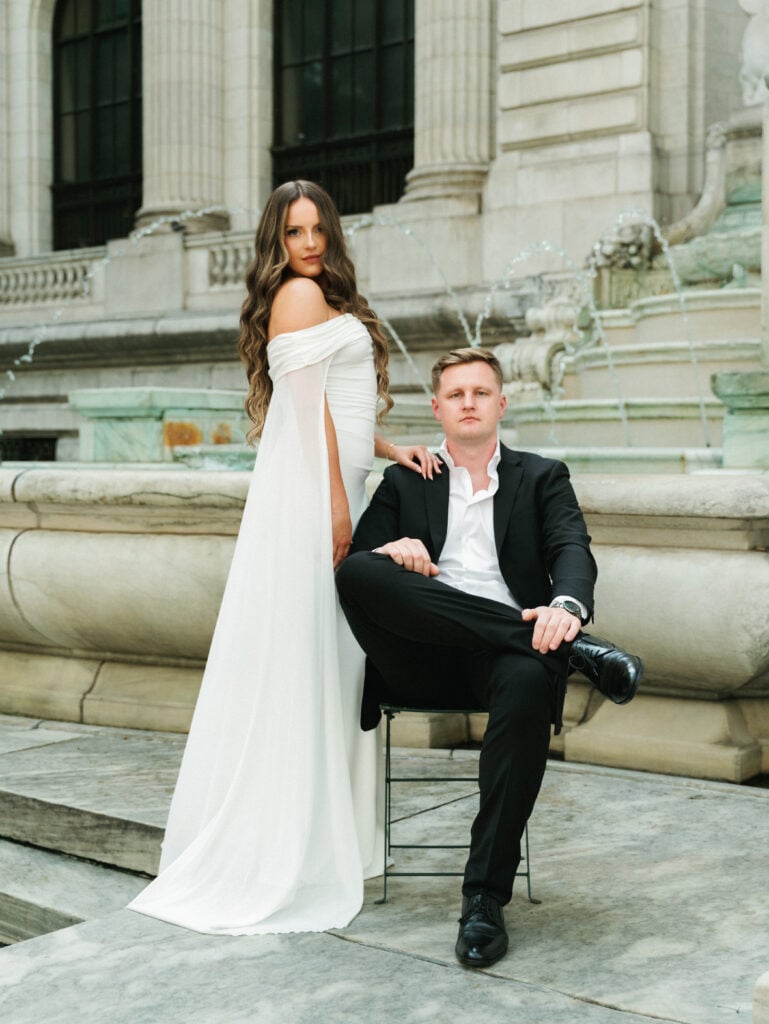 An editorial wedding portrait of a couple posing at the New York Public Library fountain in Manhattan.