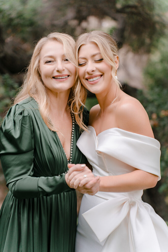 Emotional wedding portrait of a bride and her mother sharing a candid moment during a multicultural celebration.