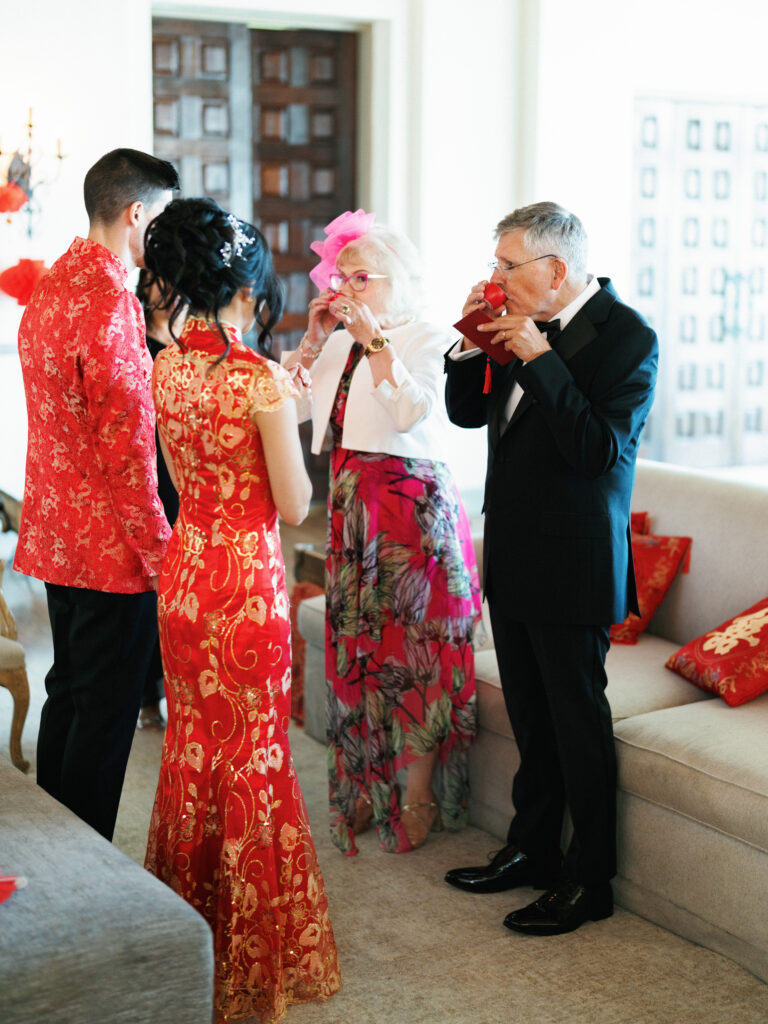 Candid wedding photography of a traditional Chinese tea ceremony during a multicultural celebration.