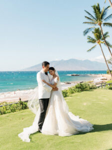 Super 8 wedding video look at a luxury oceanfront resort with bride in a lace off-the-shoulder gown and groom embracing on a tropical beachfront lawn.