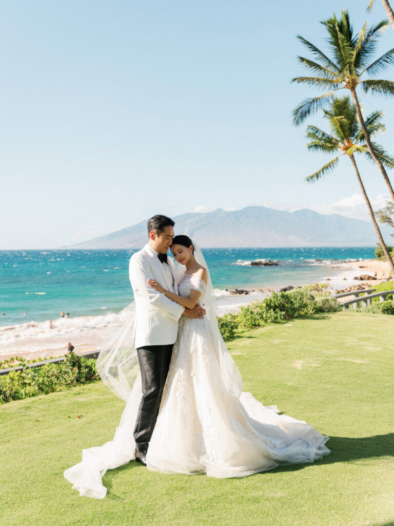 Super 8 wedding video look at a luxury oceanfront resort with bride in a lace off-the-shoulder gown and groom embracing on a tropical beachfront lawn.