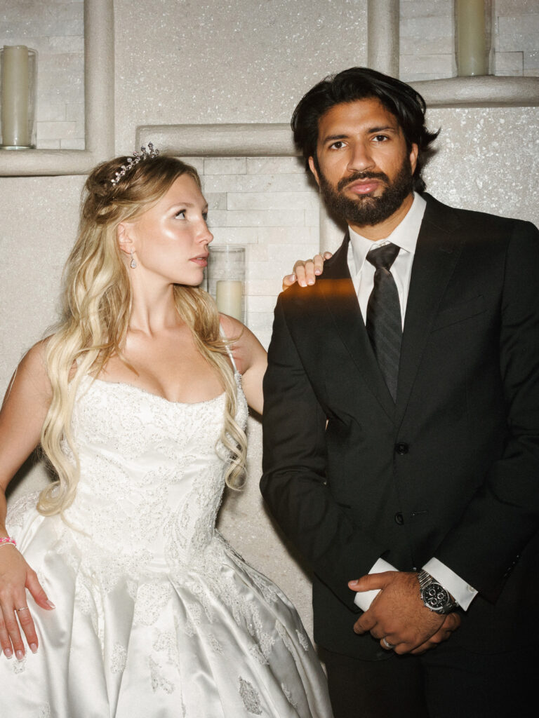 Flash photography editorial portrait of a bride and groom at a multicultural indoor wedding.