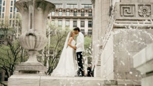A bride and groom kiss outside the historic New York Public Library wedding venue on Fifth Avenue in Manhattan.