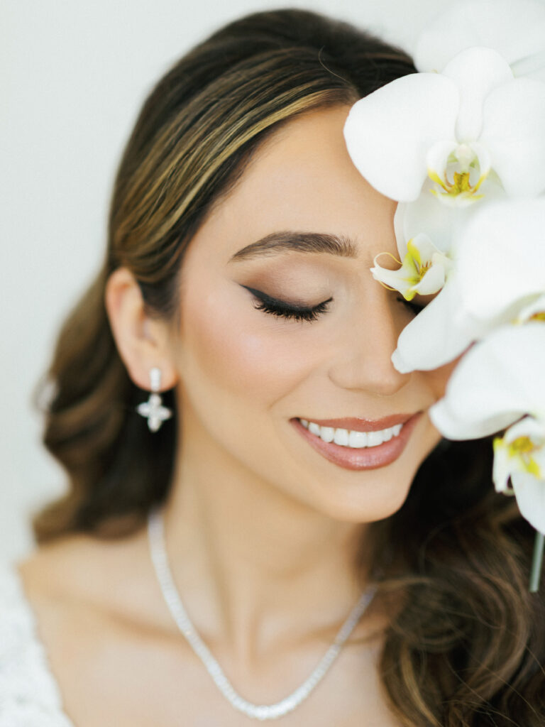 Close-up bridal portrait framed by white orchids.