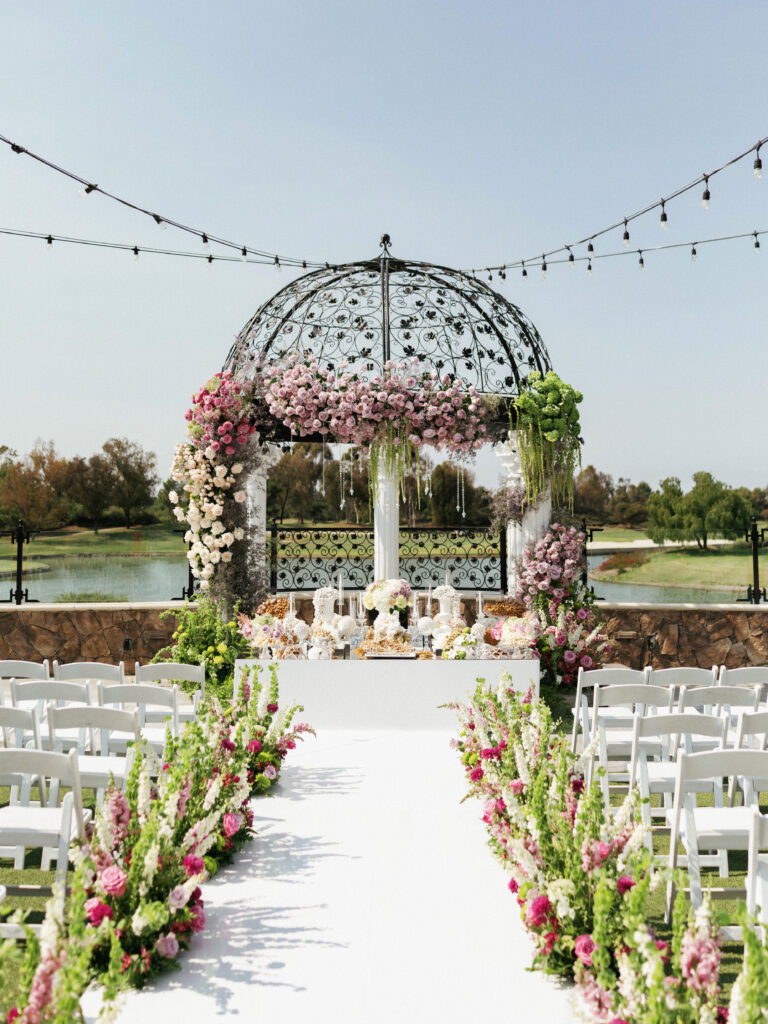 Outdoor Persian wedding ceremony setup featuring a floral-decorated gazebo and Sofreh Aghd altar.