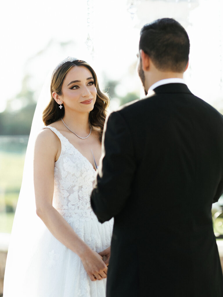 Candid fine art portrait of a bride looking at the groom during a multicultural wedding ceremony.