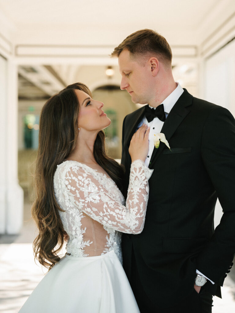 An intimate portrait of a bride in a long-sleeve lace gown and a groom in a black tuxedo for a luxury New York wedding.
