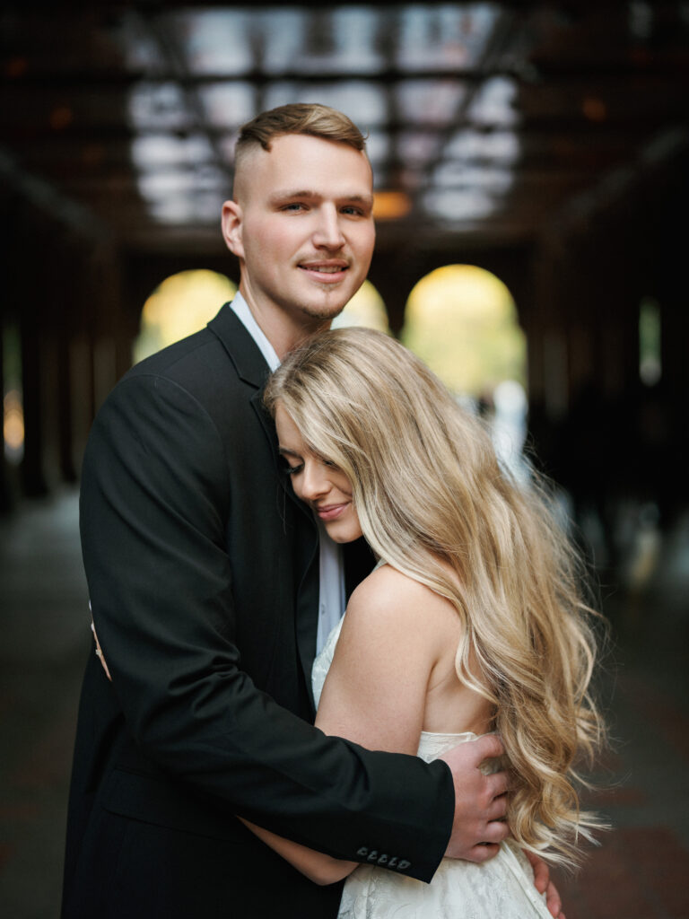 An intimate wedding portrait of a bride and groom embracing inside the historic Bethesda Terrace arcade in Central Park, New York.