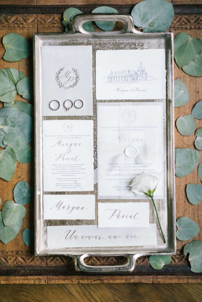 Fine art wedding invitation suite with custom sketching and wax seals, styled on a silver vintage tray with eucalyptus leaves for luxury wedding detail photos.