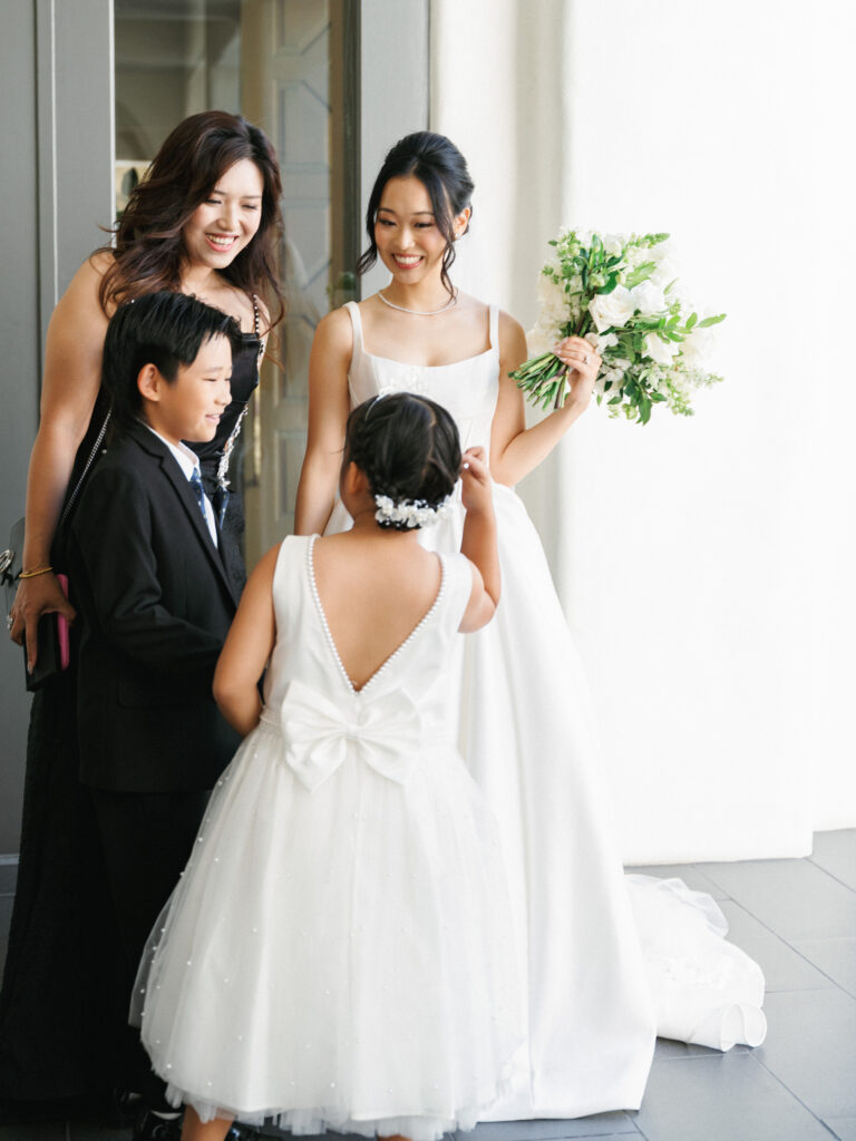 Editorial bride portrait with children, capturing authentic and unposed family moments during a luxury estate wedding reception.