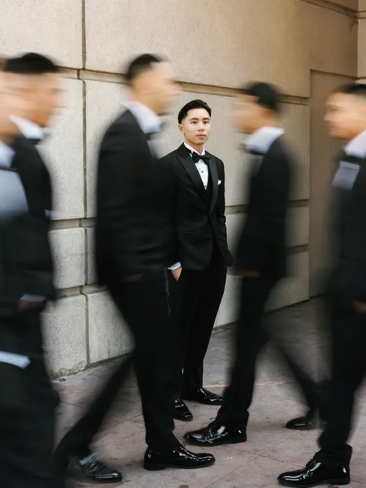 Editorial groom portrait with wedding party in motion