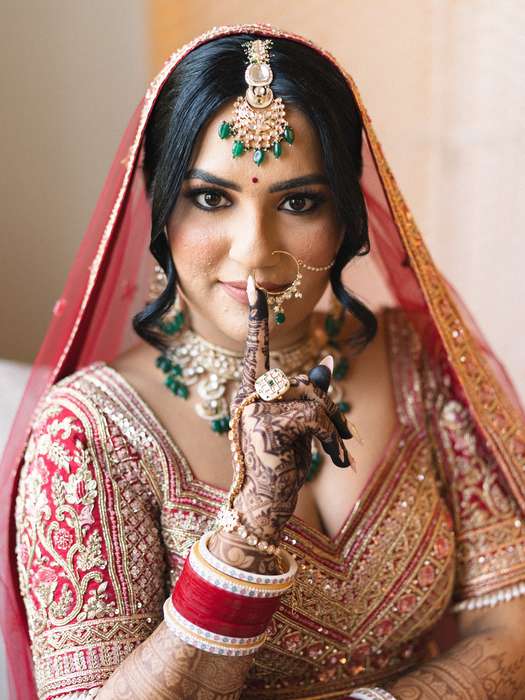 Bride in traditional wedding attire by a window