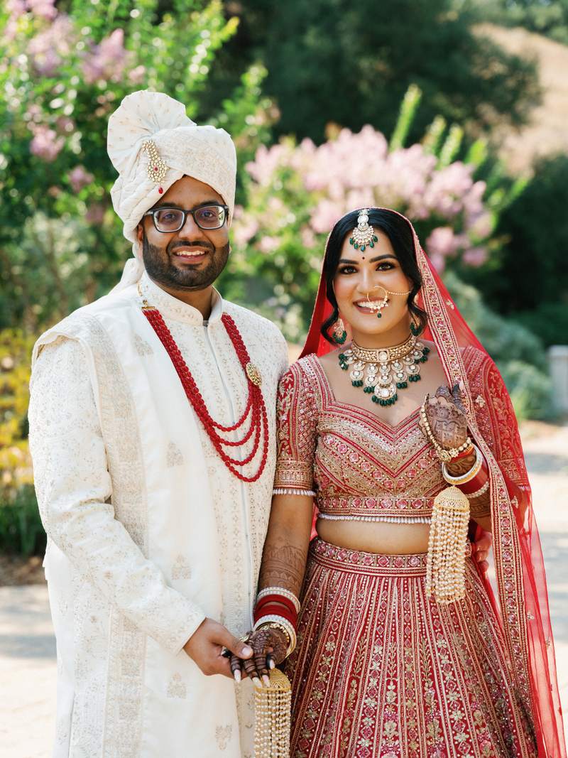 Newlyweds in traditional wedding attire outdoors