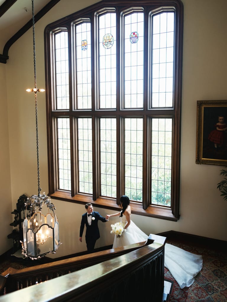 Couple walking through a bright interior with tall windows