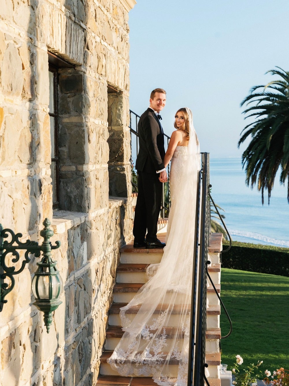 Wedding couple standing full-length on an outdoor staircase