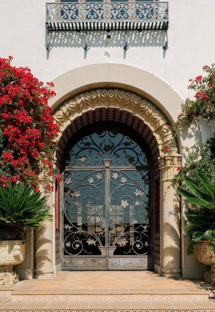 Mediterranean villa courtyard archway featuring beautiful terracotta tiles and lush tropical plants