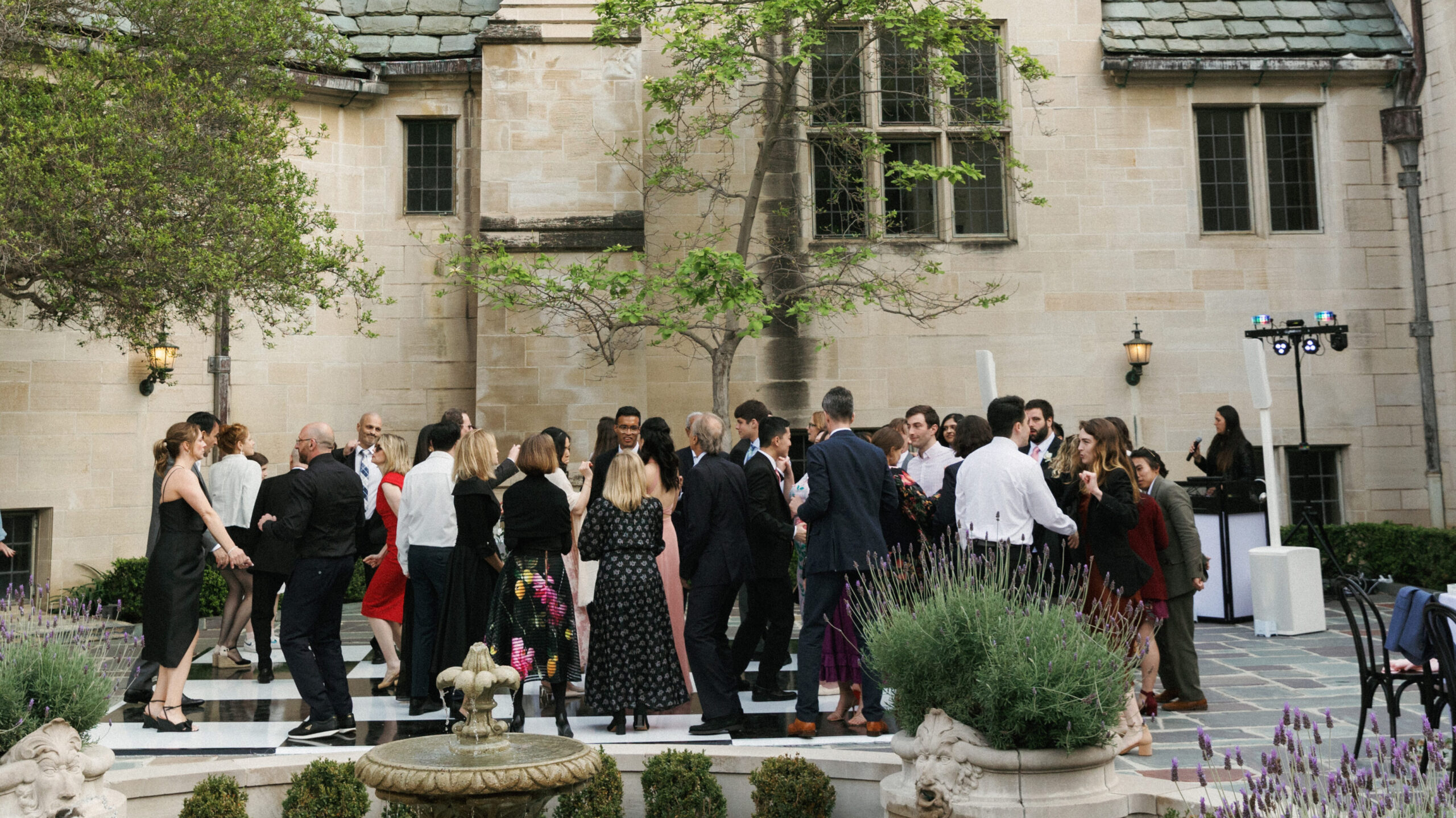 Guests dance on a classic checkered floor during a luxury outdoor celebration featured in these candid wedding reception photos