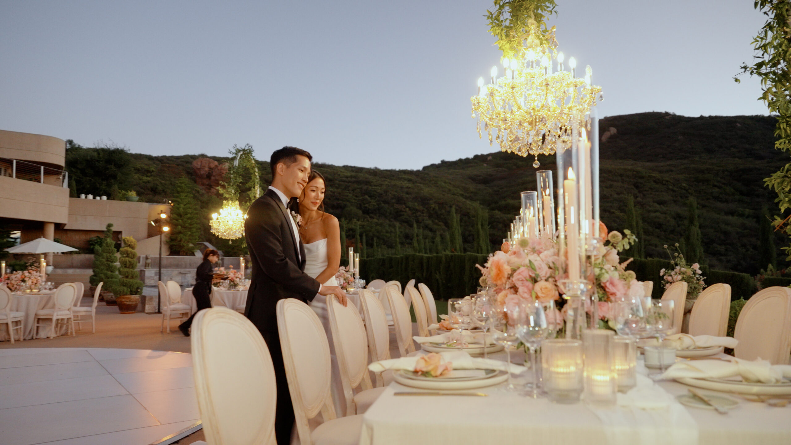 Couple beside an outdoor reception table at dusk