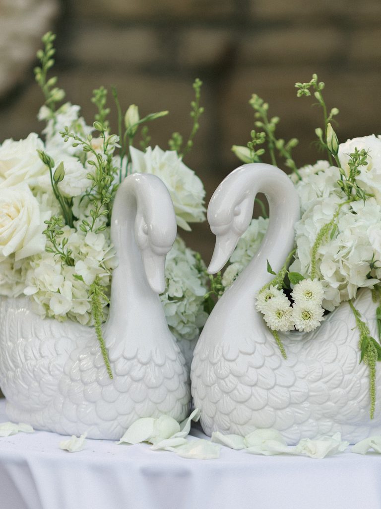 Sophisticated wedding table centerpieces with white porcelain swans and lush roses