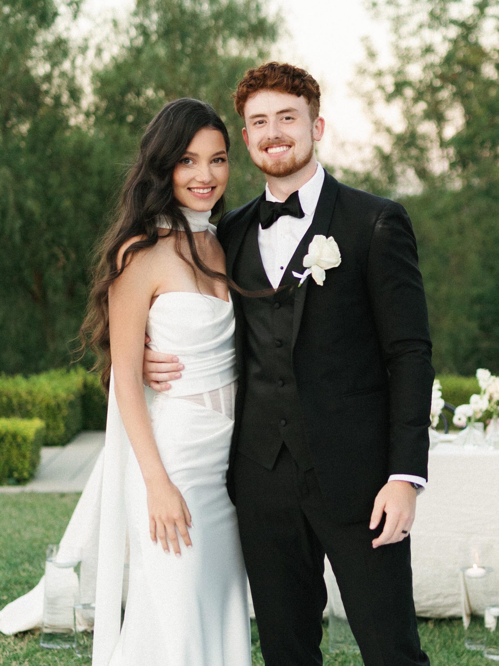 Elegant bride and groom portrait during an outdoor luxury wedding reception at dusk.