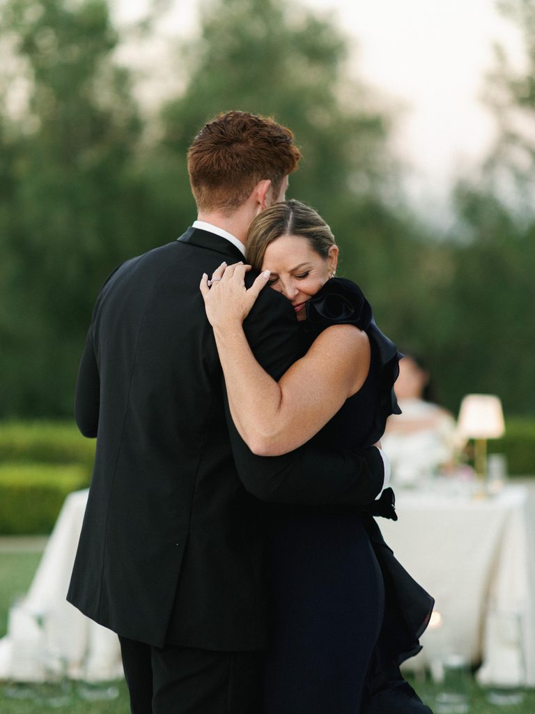An emotional mother son dance captured during an upscale outdoor celebration highlights authentic wedding reception photos