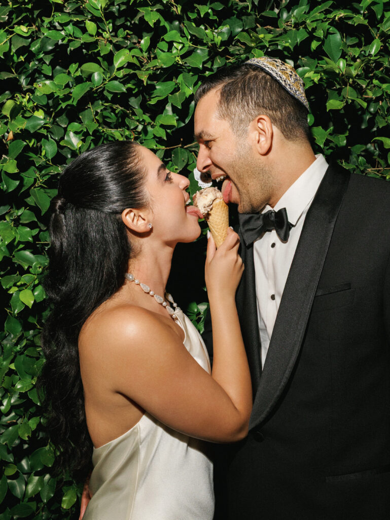 Playful bride and groom share a scoop of ice cream in these fun wedding reception photos