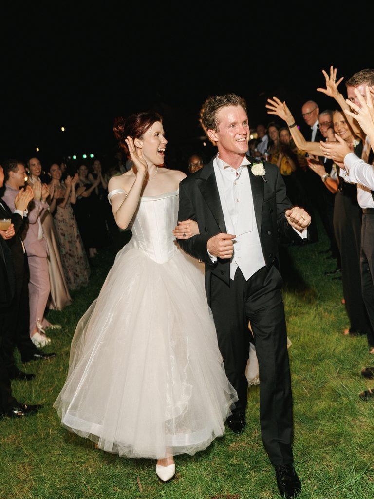 Newlyweds grand exit captured with crisp flash wedding reception lighting.