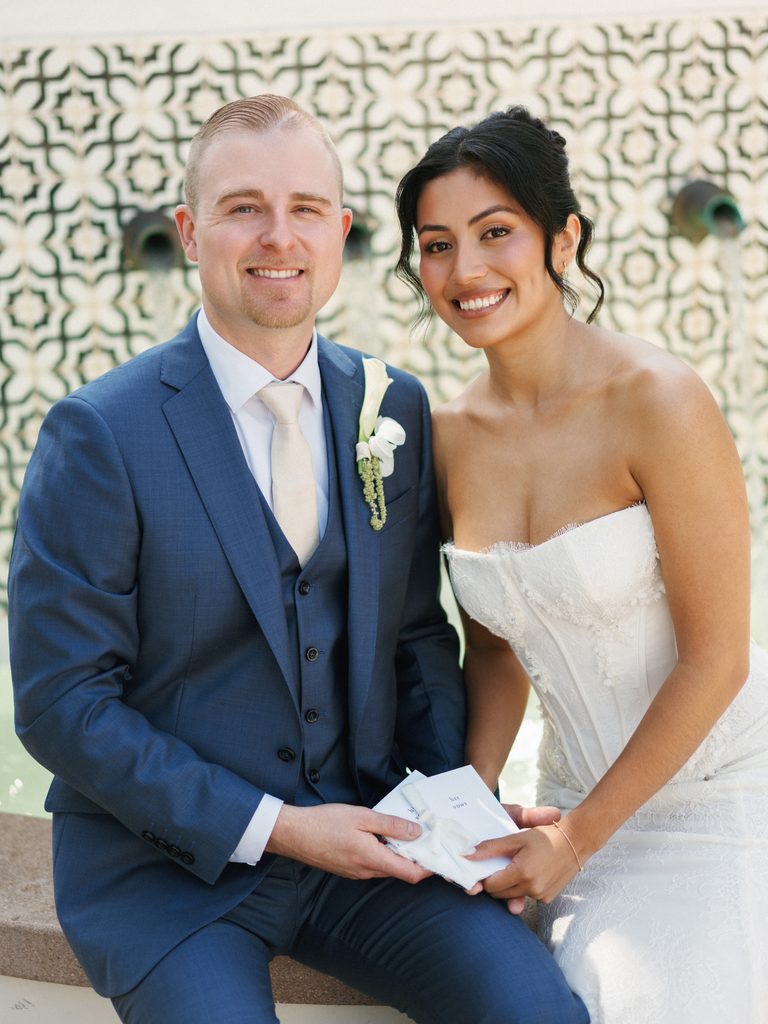 Happy bride and groom smiling at the camera during their wedding portrait hour