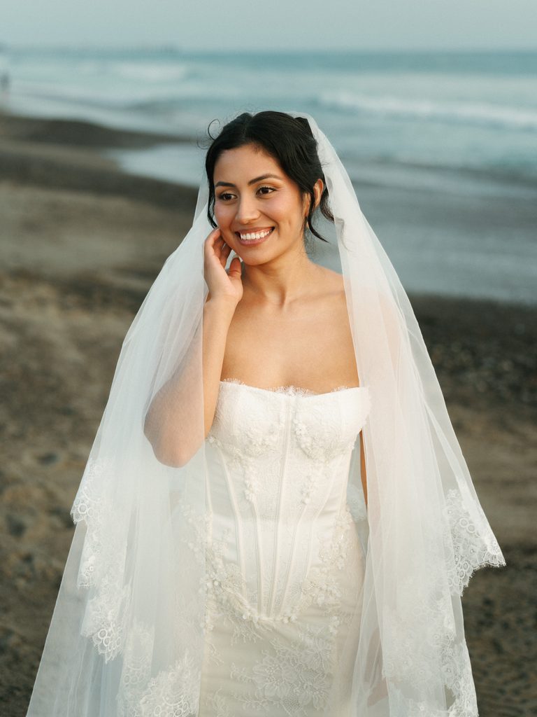 Candid beachfront bridal portrait session showcasing genuine emotions and a luxury wedding dress look