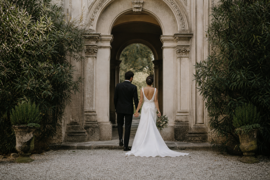 Couple walking together through an architectural arch.