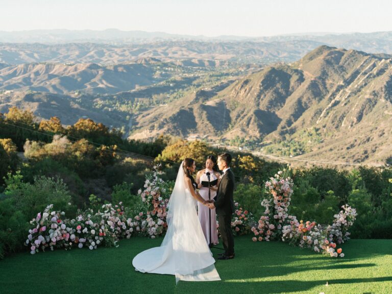 Outdoor wedding ceremony overlooking layered mountain ridges
