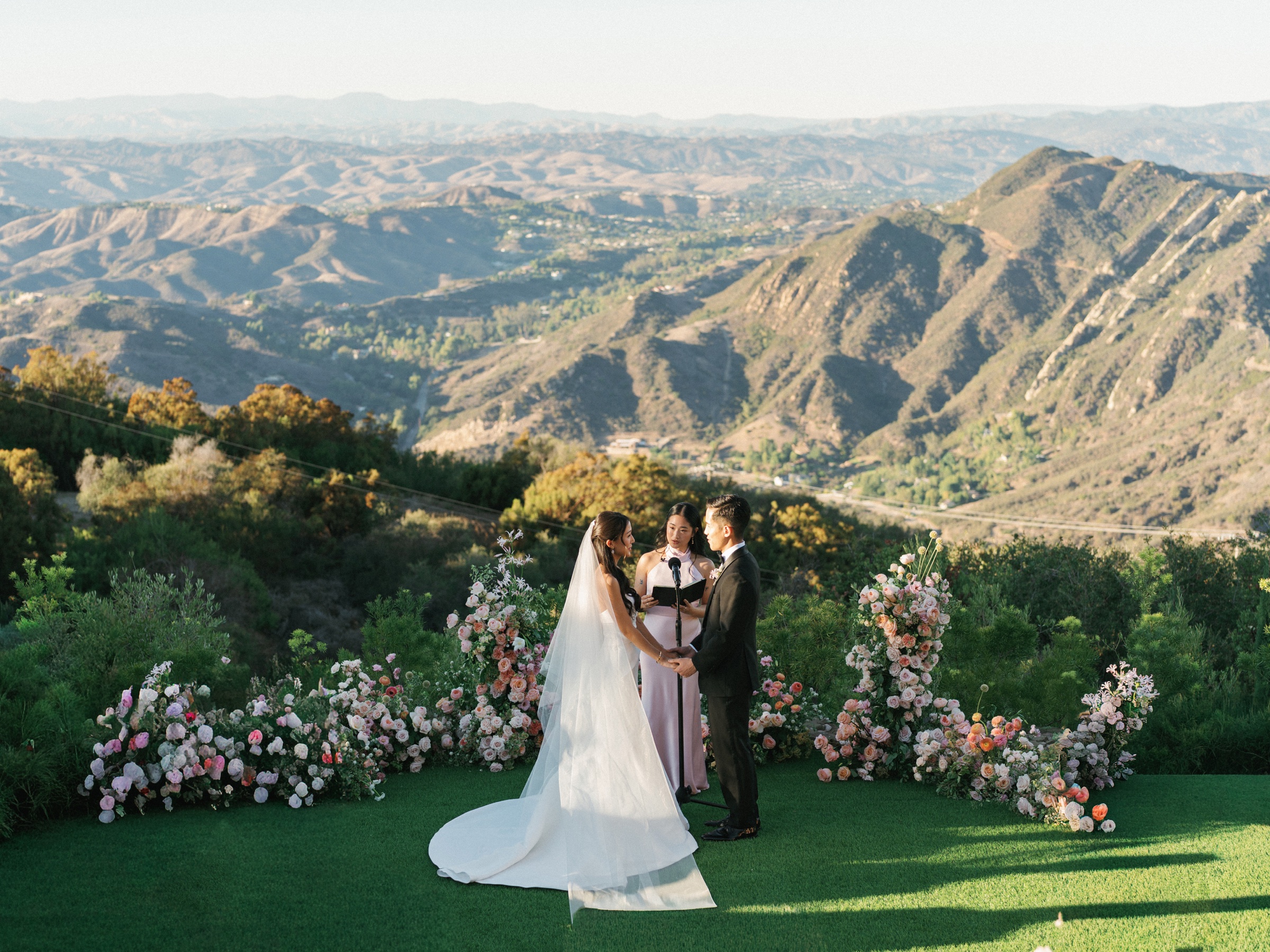 Outdoor wedding ceremony overlooking layered mountain ridges