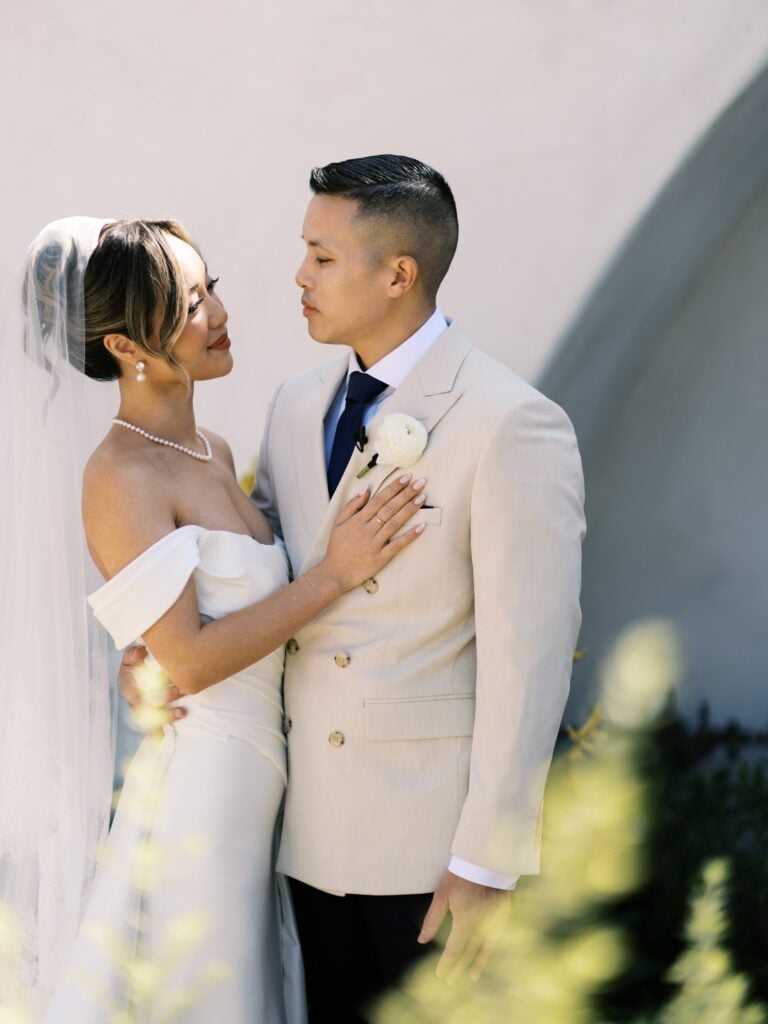 Bride and groom stand close together during an outdoor wedding portrait