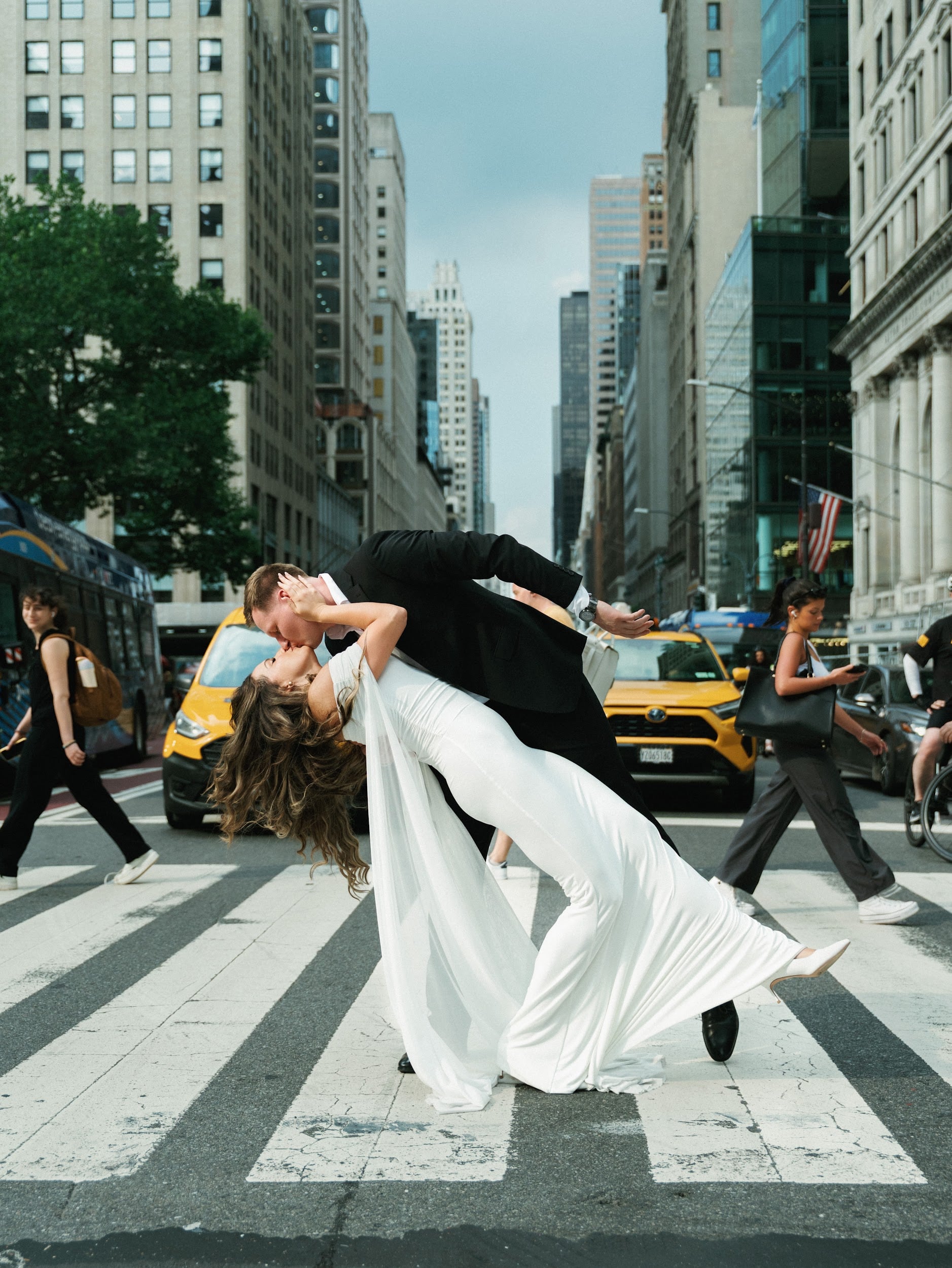 Newlyweds kiss on a city crosswalk during an urban wedding portrait