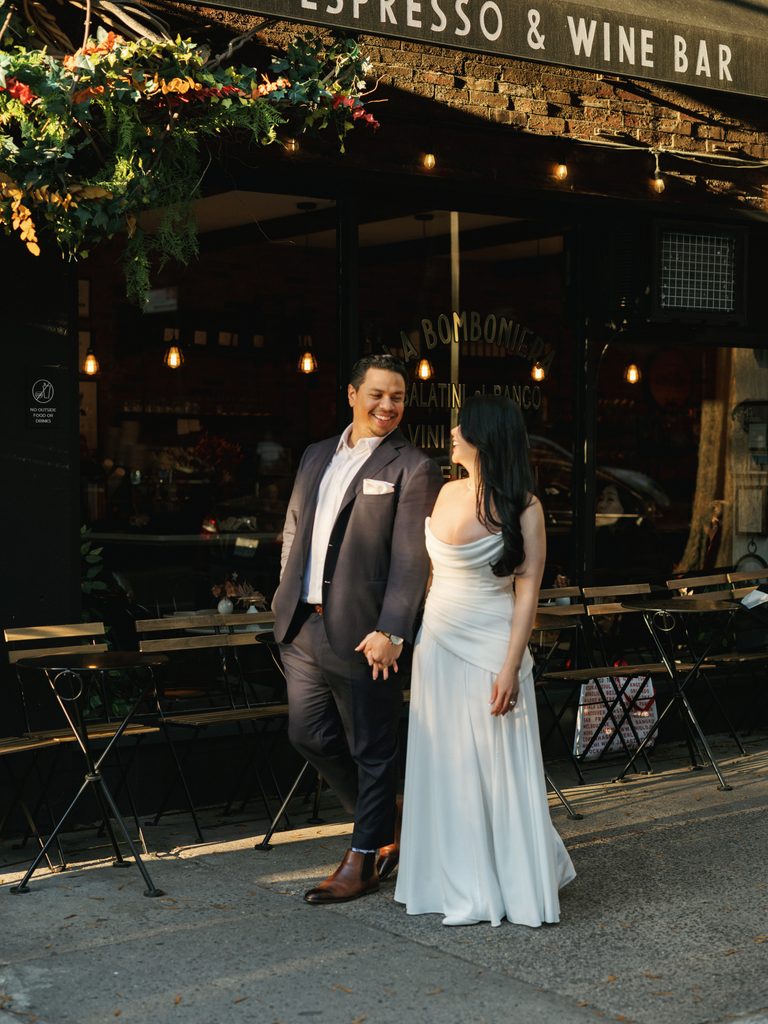 Elegant couple walking outside an upscale coffee shop with hanging flower planters inspiring urban engagement photo ideas